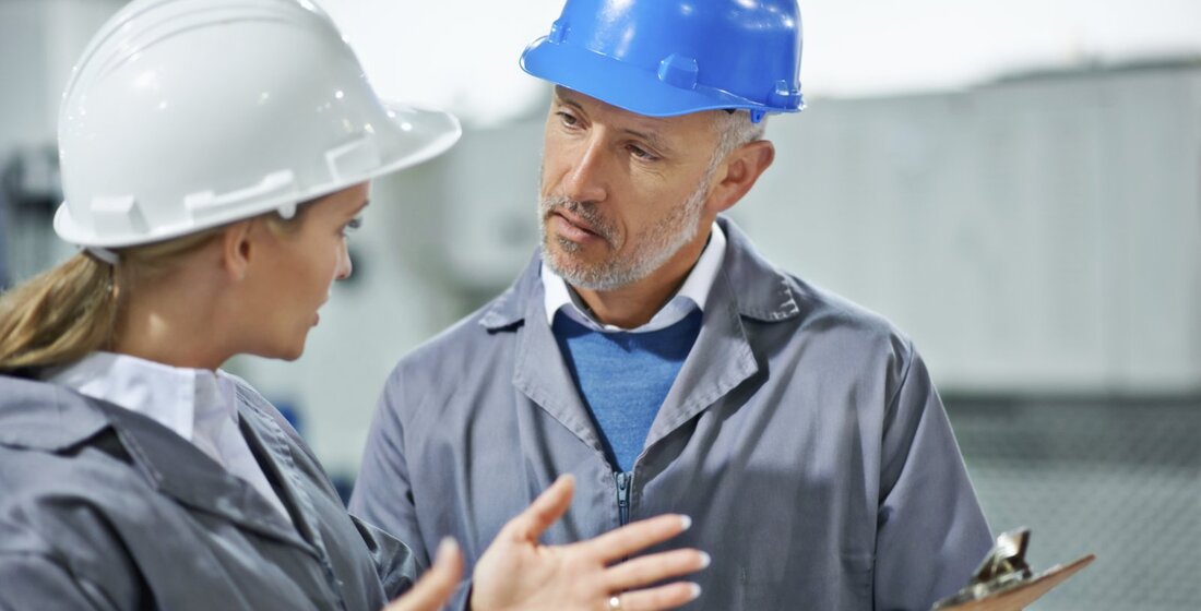 Zwei Ingenieure mit Schutzhelm im Gespräch